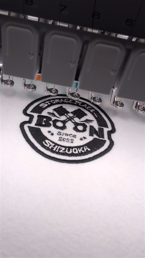 刺繍機でBOONの丸いロゴを縫い上げている様子